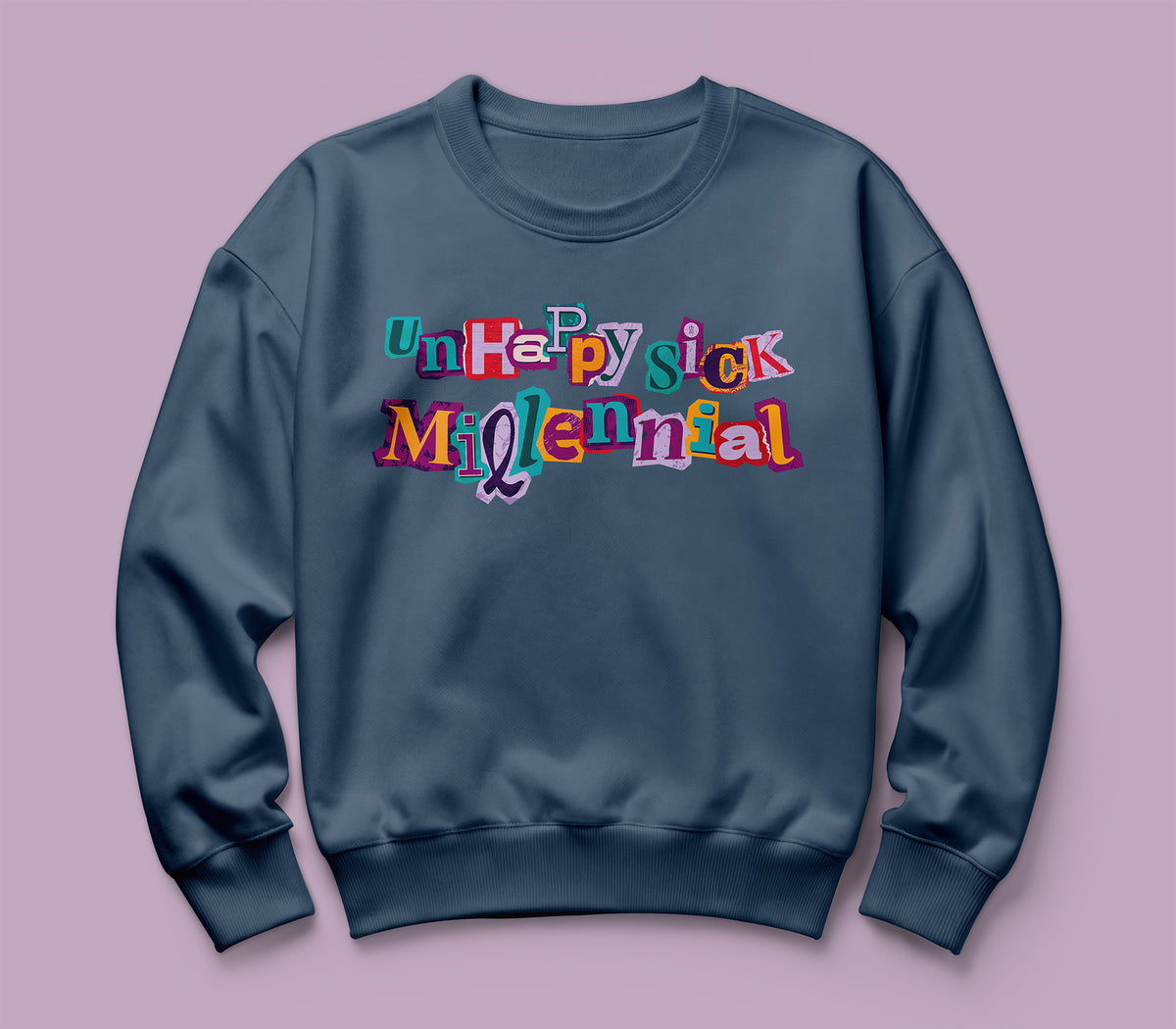 A navy blue Comfort Colors crewneck sweatshirt featuring a colorful graphic text print that reads 'unhappy sick millennial' in a playful, multi-colored retro font, displayed against a solid dusty purple background.